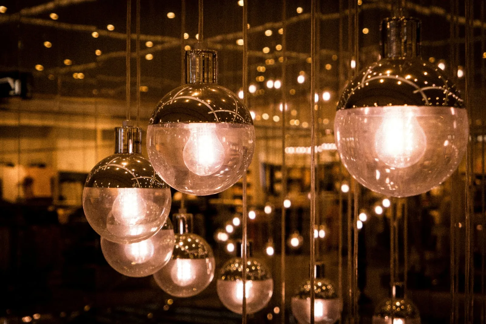 Cluster of matching glass globe LED pendant lights illuminated in a commercial space